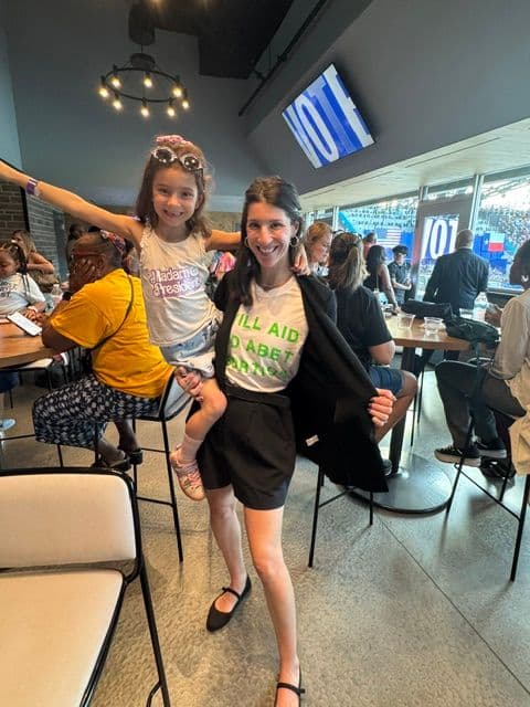 Abby and her daughter Ava at a Harris rally in Dallas, TX in October 2024.